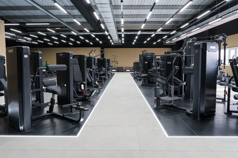 A training floor laid out with Bodytone strength machines on either side of a lit walkway.